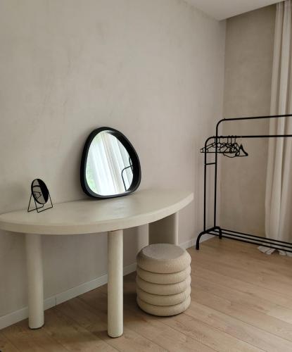 a round mirror sitting on a table in a room at Casa L in Ulcinj