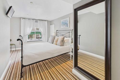 a bedroom with a bed and a large mirror at Host & Stay - Luna Cottage in Staithes