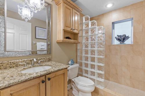 a bathroom with a toilet and a sink and a mirror at Atlantic Villas 101 in New Smyrna Beach