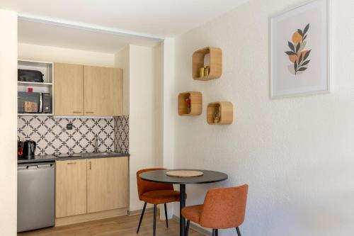 une petite cuisine avec une table et des chaises dans l'établissement Travel Homes - The Pfeffel, 2m walk Little Venice, à Colmar