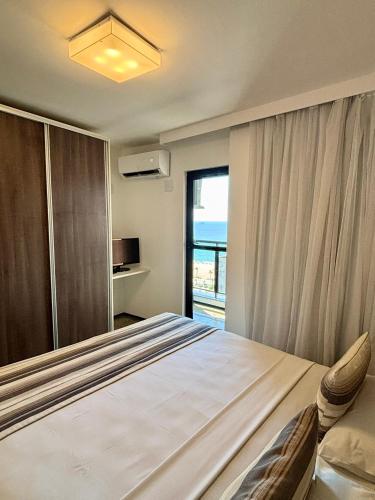 a bedroom with a bed and a large window at Hotel Brasil Tropical in Fortaleza
