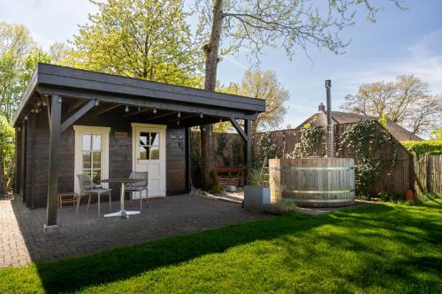 a small shed with a table in a yard at Bed & breakfast De Loeghoeve in Anderen