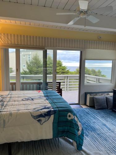 a bedroom with a large bed and a balcony at New Seabury Ocean Front Beach Condo 2Bd2Bath 2 Large Balconies Private Beach in Mashpee