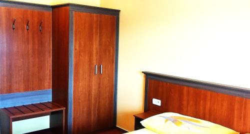 a bedroom with a bed and wooden cabinets at Pension Javorník in Jeřmanice