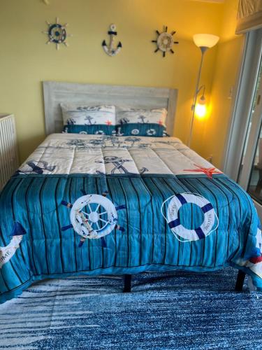 a bedroom with a bed with a blue comforter at New Seabury Ocean Front Beach Condo 2Bd2Bath 2 Large Balconies Private Beach in Mashpee