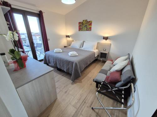 a bedroom with a bed and a chair in it at COMIDA Guesthouse & Experiences in Tortolì