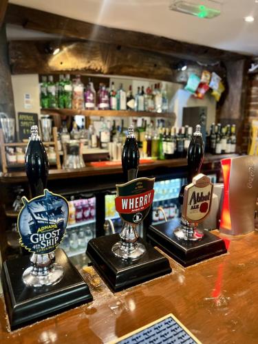 a bar with three wine glasses on a counter at The Parson Woodforde in Norwich