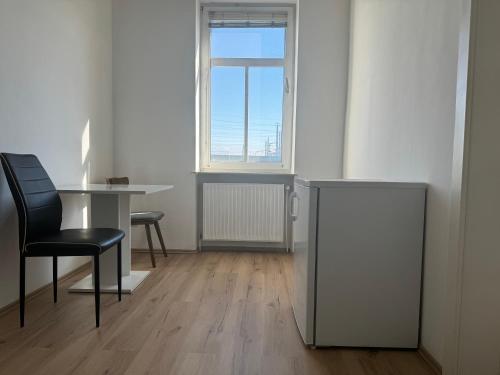 una stanza con un tavolo, una sedia e una finestra di Zimmer & Apartments Amstetten ad Amstetten