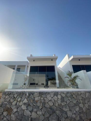 a house with a stone wall in front of it at Tills Beach Resort in Fetta