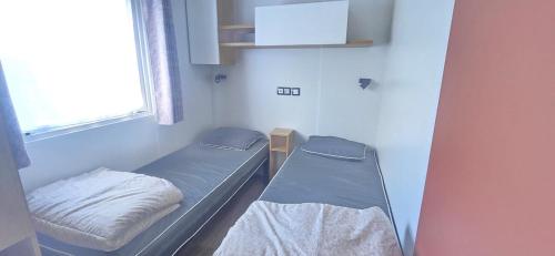 a hospital room with two beds and a window at MOBIL HOME CAMPING LES SABLES DU MIDI 3 chambres in Sérignan