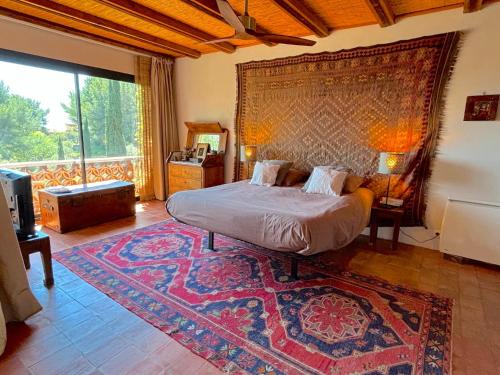 - une chambre avec un lit et un grand tapis dans l'établissement Villa Micéa, à Sanary-sur-Mer