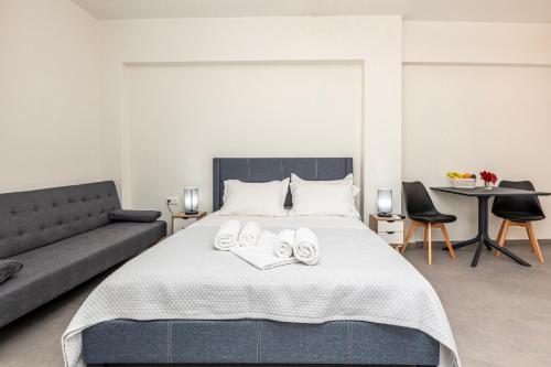 a bedroom with a bed with a couch and a table at Demar Studios in Lefkogeia