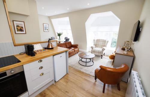 a kitchen with a desk and a living room at Cosy Apartment in the Heritage Quarter - Sleeps 2 in Dunfermline