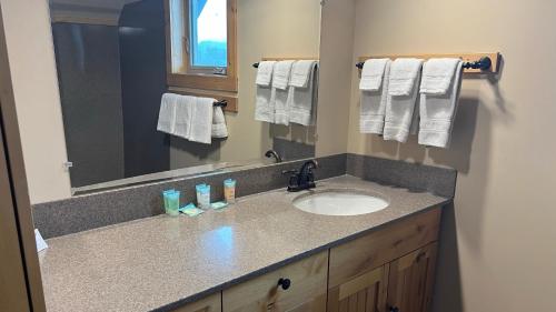 a bathroom with a sink and a mirror and towels at Methow River Lodge and Cabins in Winthrop