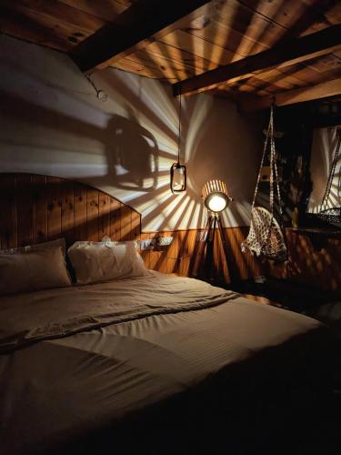 a bedroom with a bed in a room with a light at The heavens place wooden room in Nagar