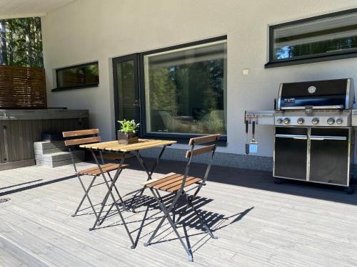 un patio con tavolo, sedie e griglia di Sauna cottage in Nuuksio a Espoo