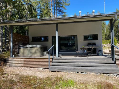 una casa con terrazza in legno e griglia di Sauna cottage in Nuuksio a Espoo