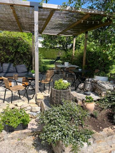 a patio with a table and chairs under a pergola at La Longère de Bourgogne in Demigny