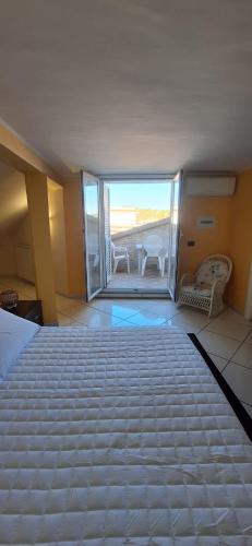 a bedroom with a bed and a balcony with a table at Villa Sara B&B in Civitavecchia