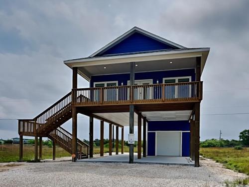 a blue house with a deck and a garage at Fish Tales in Lamar