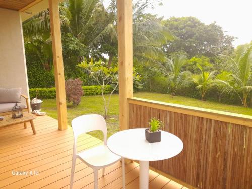 a porch with a white table and chairs and a window at Les Pêcheurs in Le Morne