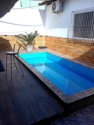 une piscine avec une table et une chaise dedans dans l'établissement Pousada Recanto Alto da Boa Vista, à Cachoeira Paulista