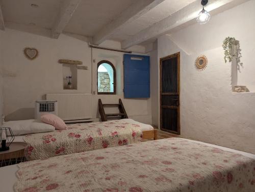 une chambre avec deux lits et une table et une fenêtre dans l'établissement La Bergerie de Lorette - Au Cœur du Luberon, à Bonnieux