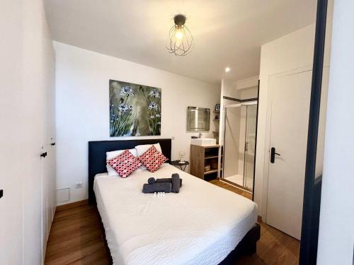 une chambre avec un lit avec des oreillers rouges et blancs dans l'établissement Casamea - Vue Mer, Terrasse, 5 min plage, Clim, à Ajaccio