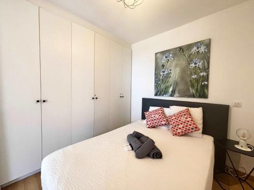 une chambre avec un lit avec des oreillers rouges et blancs dans l'établissement Casamea - Vue Mer, Terrasse, 5 min plage, Clim, à Ajaccio