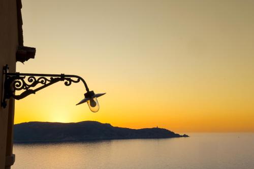 a street light with the sunset in the background at Le Saint Erasme, Hotel Eco Friendly in Calvi