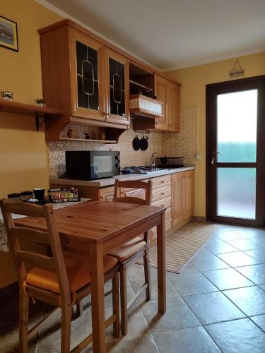 a kitchen with a wooden table with chairs and a microwave at Il PETTIROSSO in Galbiate