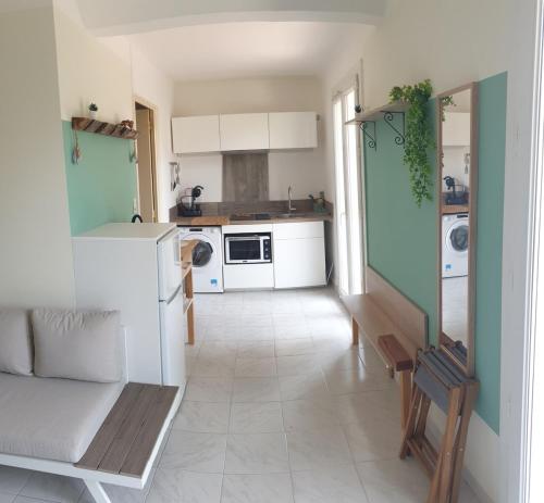 Il comprend une cuisine avec des placards blancs et du carrelage blanc. dans l'établissement studio à 5 minute à pieds de la mer, à Sanary-sur-Mer