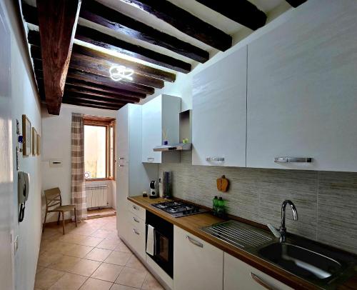 a kitchen with white cabinets and a sink at Locazione turistica via Aurelio Saffi 5 in Foligno
