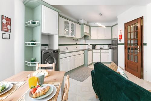 a kitchen with a table with a plate of food on it at Vila Florida - T2 familiar perto da praia in São Martinho do Porto