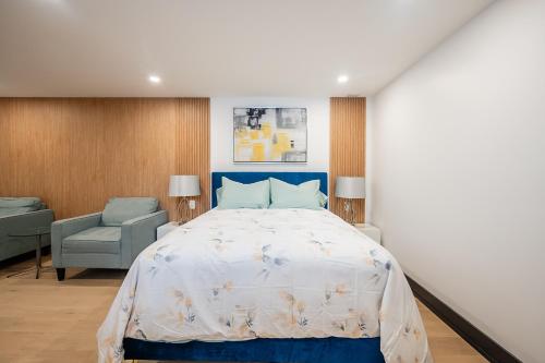 ミシサガにあるTranquil 2bedroom basement in charming Mississaugaのベッドルーム(青いベッド1台、椅子付)