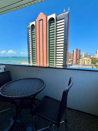 a table and chairs and a view of a city at Hotel Brasil Tropical in Fortaleza