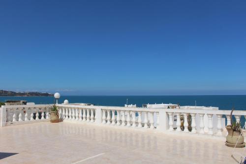 a white balcony with the ocean in the background at Élégant Appartement à La Marsa avec Vue sur Mer Et une Grande Terrasse Privée in Tunis