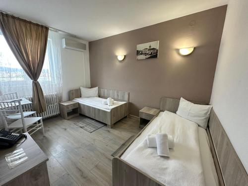 a bedroom with two beds and a room with a window at Motel Dacia in Sebeş