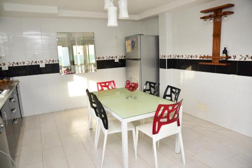 a kitchen with a table and chairs in a kitchen at Élégant Appartement à La Marsa avec Vue sur Mer Et une Grande Terrasse Privée in Tunis