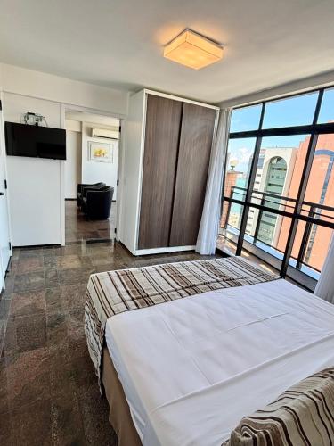 a bedroom with a large bed and a bathroom at Hotel Brasil Tropical in Fortaleza