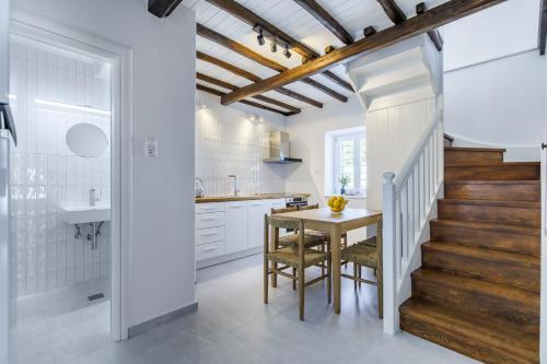 a kitchen with white cabinets and a table with chairs at Villa Skopelita in Skopelos Town