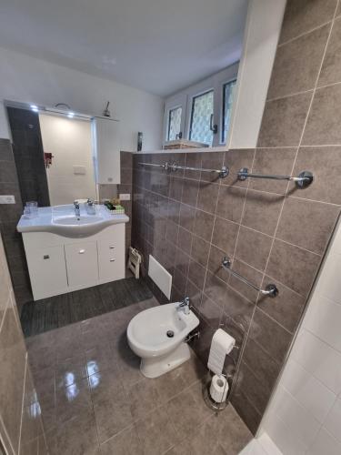 a bathroom with a toilet and a sink at Relaxing and Comforting in Olbia