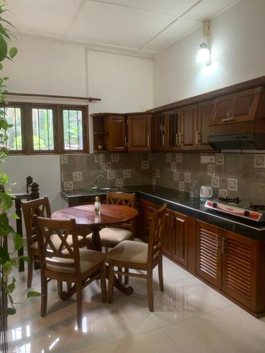 a kitchen with a wooden table and chairs and a tableasteryasteryasteryasteryastery at Captain's Ridge in Nattarampota