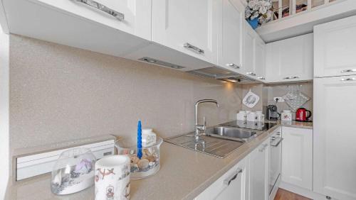 une cuisine avec des armoires blanches et un évier dans l'établissement CASA LUNA - sur les canaux de Port-grimaud, à Grimaud