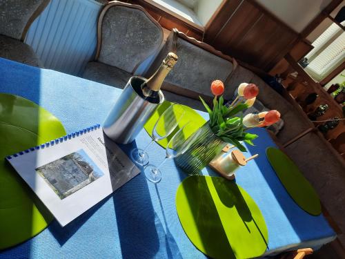 a bottle of wine and a vase with flowers on a table at Chalupa u Potoka in Čestice