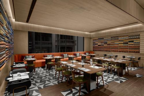 a restaurant with tables and chairs in a room at Hotel Indigo Saigon the City by IHG in Ho Chi Minh City