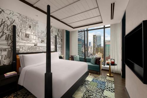 a bedroom with a bed and a living room at Hotel Indigo Saigon the City by IHG in Ho Chi Minh City