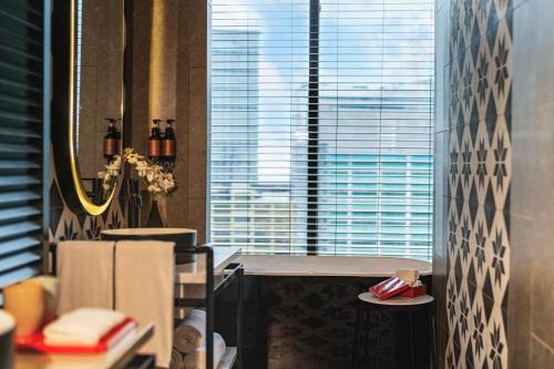 a bathroom with a view of a large window at Hotel Indigo Saigon the City by IHG in Ho Chi Minh City