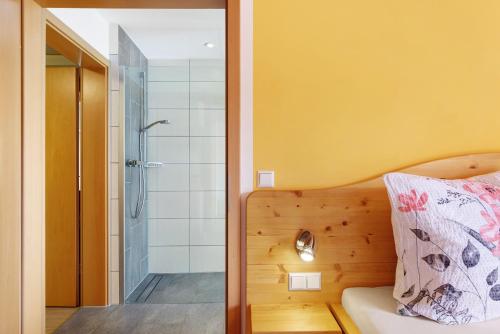 a bedroom with a shower and a bed with a pillow at Ferienwohnung Haus Brunner in Grafenhausen