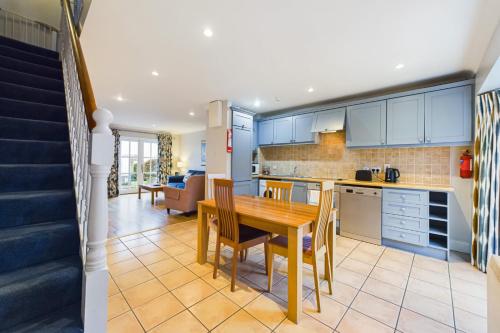 a kitchen with blue cabinets and a table and chairs at Faithlegg Mews, Faithlegg in Waterford